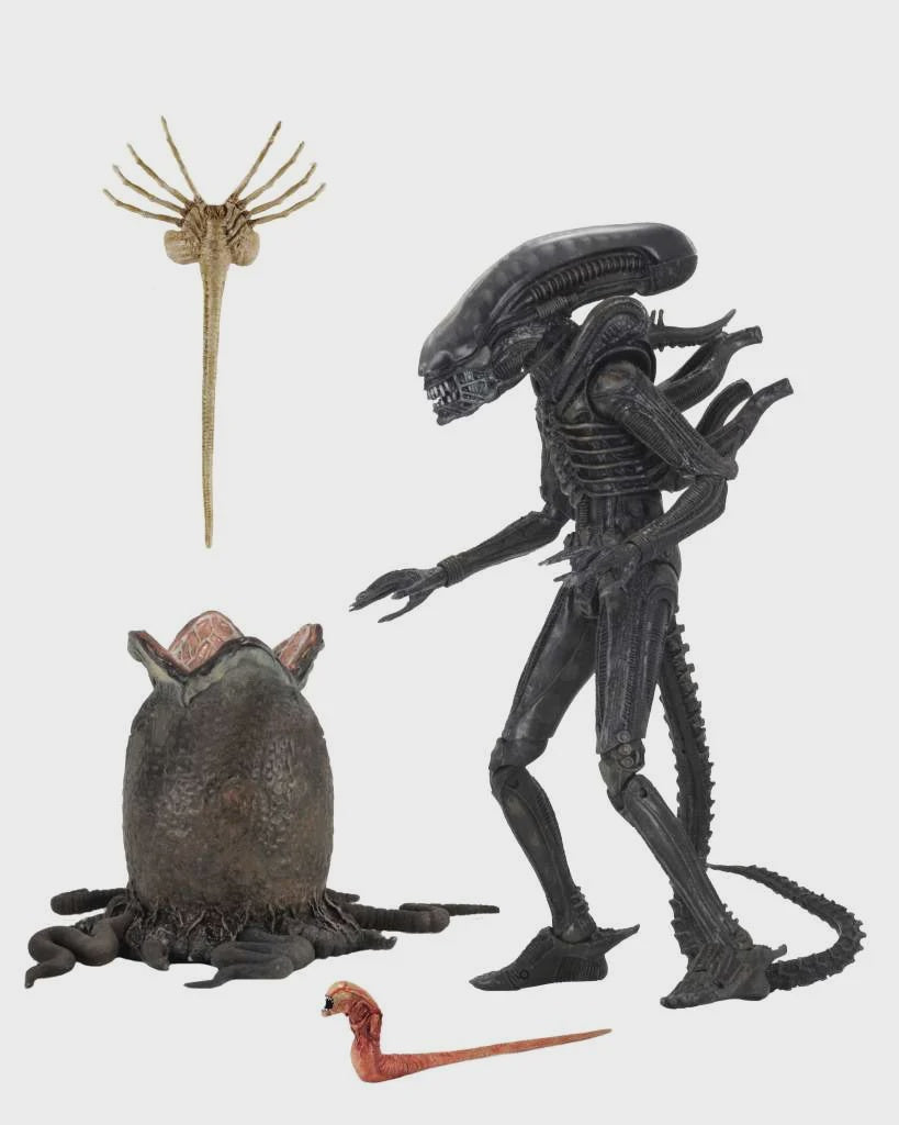 Action figures of an alien and a creature from a science fiction movie on a white background