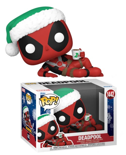 A Funko Pop! Deadpool figurine with a festive hat and a cup, packaged in a holiday-themed window display box.