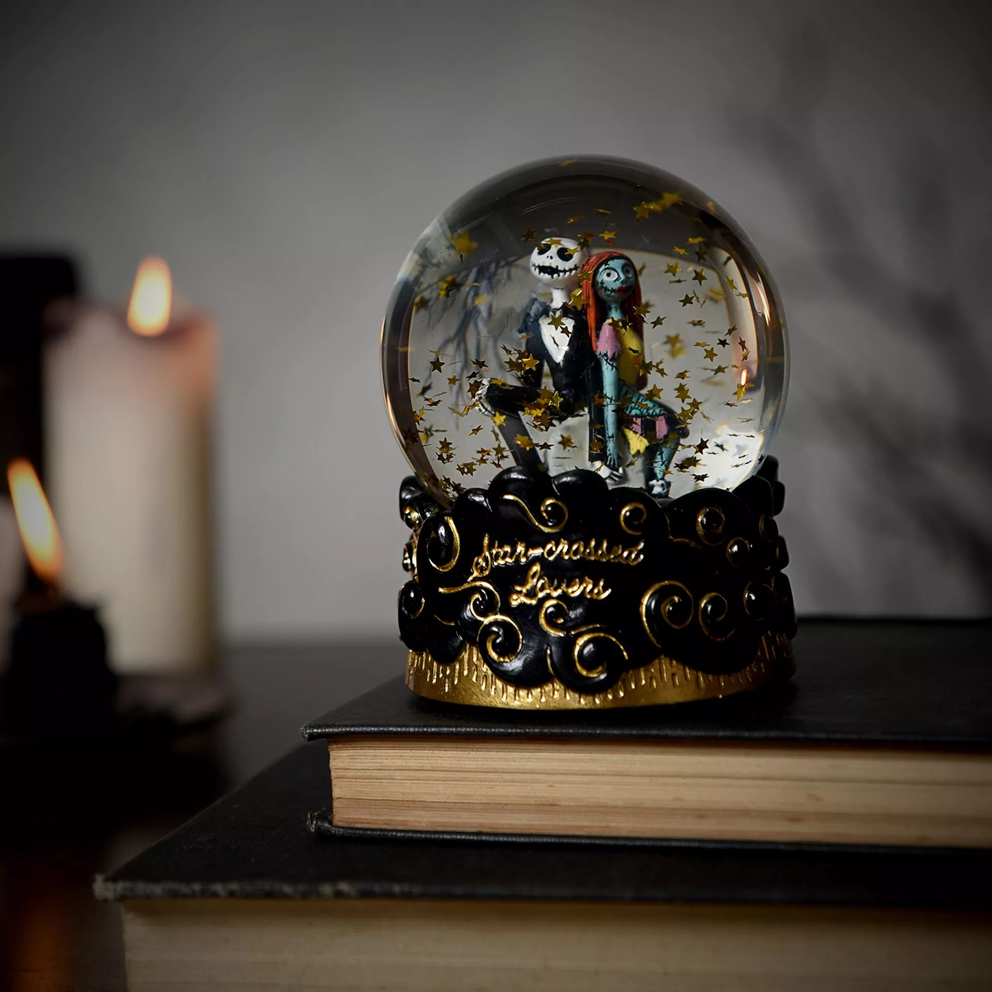Decorative snow globe with characters on a book against a dark background