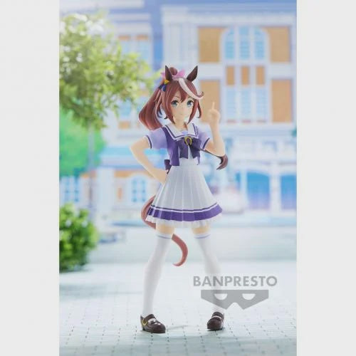 A figurine of a anime-style character from UMAMUSUME : PRETTY DERBY, wearing a school uniform, standing against a backdrop of a street and building.