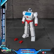 Transformers toy figure with red hands on a dark surface, featuring AMK Mini Series packaging.