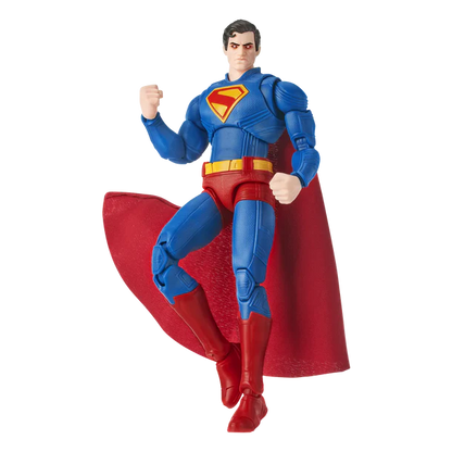 Superman action figure in a dynamic flying pose, featuring a blue bodysuit with a red and yellow chest emblem, a flowing red cape, and red boots, photographed on a plain white background.