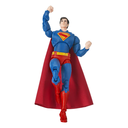 Superman action figure in a dynamic flying pose, featuring a blue bodysuit, red cape, red boots, and a yellow chest emblem on a plain white background.