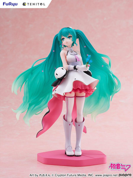 Figurine of a character with teal hair and a white outfit on a pink background