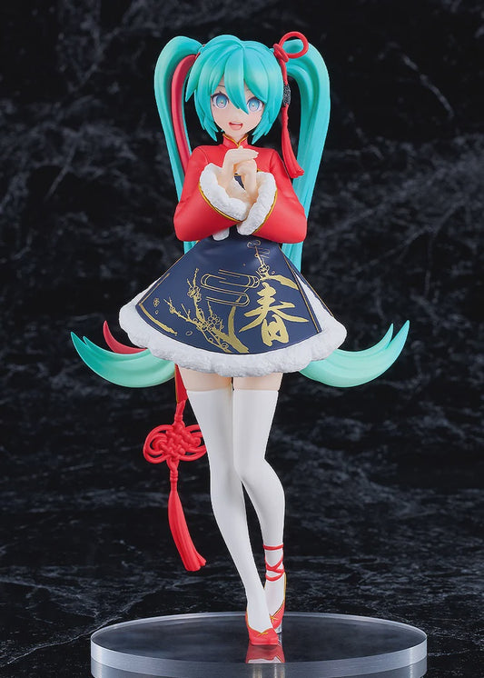 Anime character figurine with teal hair and red outfit on a dark background