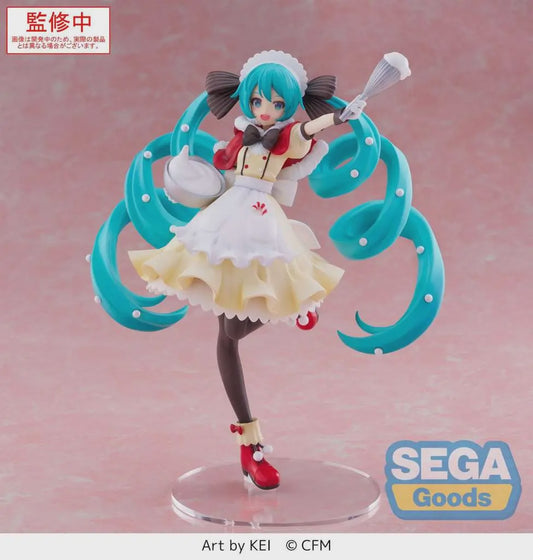 A collectible anime figure of Hatsune Miku in a maid outfit with turquoise twin-tails, posed on a clear round base against a soft pink studio background. Visible text includes SEGA Goods branding and 'Art by KEI © CFM'; the top-left red label appears to be a production-status overlay.