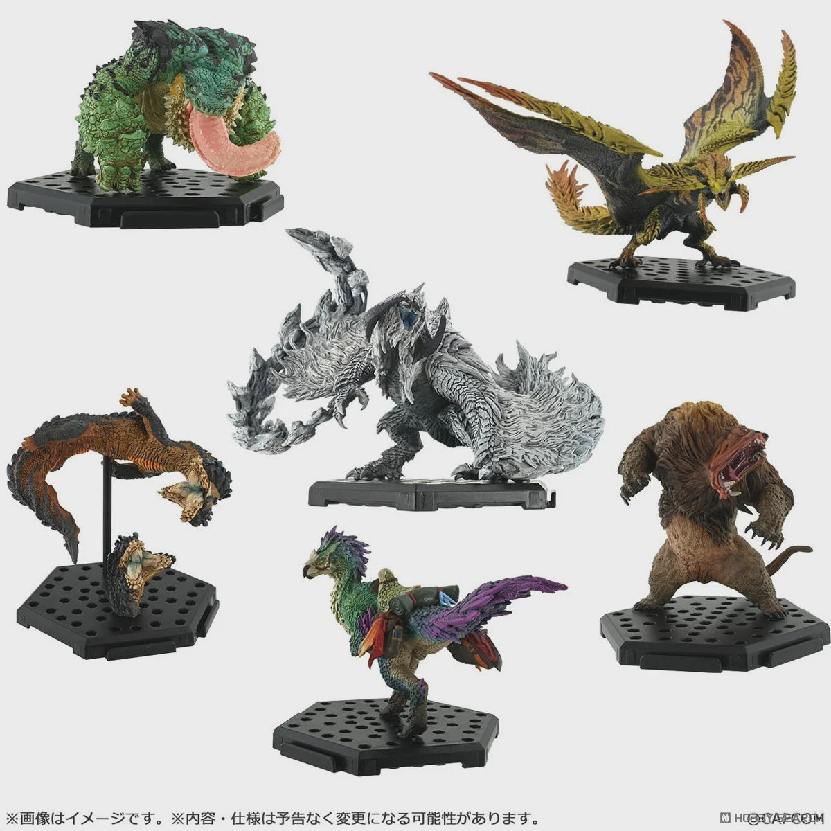Collection of various monster figurines on black stands against a white background