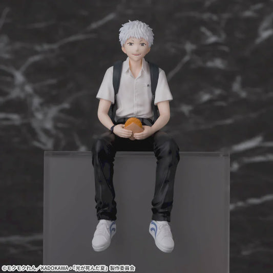 Figure of a person sitting on a block with a blurred background